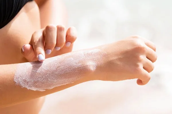 Sonnencreme wird auf dem Unterarm verteilt